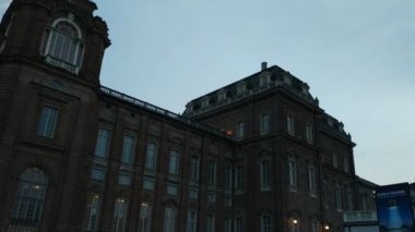 Venaria Reale, İtalya - Temmuz 2019: Piazza della Saat kulesine girin. İnsanlar akşamları serinliyor. Pan hareketi 