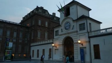 Piedmont, İtalya - Temmuz 2019: Piazza della β bblica sarayın girişi. Saat kulesine girin. İnsanlar akşamları serinliyor.