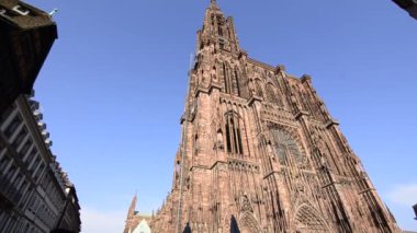 Strasbourg, Fransa - Ağustos 2019: Leydimizin 142 metre yüksekliğindeki muhteşem katedrali, daha yüksek binalar için karşılaştırma süresiydi. Kızıl faade çok etkileyici. Pan hareketi.