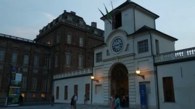Piedmont, İtalya - Temmuz 2019: Piazza della β bblica sarayın girişi. Saat kulesine girin. İnsanlar akşamları serinliyor.