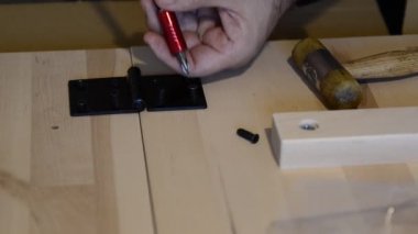 İki hafif tahta üzerinde siyah metal bir menteşeyle tamir ediliyor. Tornavida düzüşmek için kullanılır..