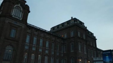 Venaria Reale, İtalya - Temmuz 2019: Piazza della Saat kulesine girin. İnsanlar akşamları serinliyor. Pan hareketi 