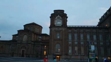 Piedmont, İtalya - Temmuz 2019: Piazza della β bblica sarayın girişi. Saat kulesine girin. İnsanlar akşamları serinliyor.