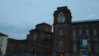 Piedmont, İtalya - Temmuz 2019: Piazza della β bblica sarayın girişi. Saat kulesine girin. İnsanlar akşamları serinliyor.