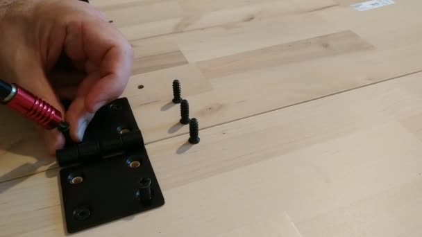用黑色金属铰链固定在两个轻型木板上 螺丝刀是用来做螺丝的 — 图库视频影像