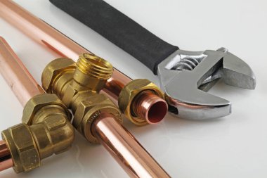 Bakır boru inşaat ayarlanabilir anahtarı, 15 mm bakır boru ve pirinç ek yerleri için hazır yeni birlikte gri bir arka plan karşı koydu