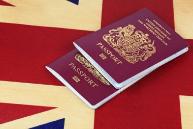 Flag and passports  Two united Kingdom passports on a Union Jack background clipart