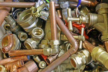 Plumber's pipes and fittings       Random mixture of copper pipe and brass fittings ideal for use as a website header  background clipart