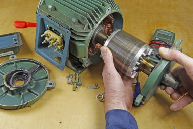 Üç fazlı endüksiyon motor taşıyan onarmak bir tesisatçı/teknisyen şaft yatakları değiştirme önce statör rotor kaldırılıyor