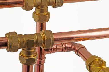 Pipework and fittings -  Copper pipe and compression fittings isolated on a white background  clipart