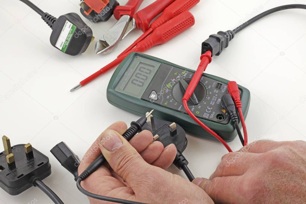 Earth continuity testing  An electrician testing a mains cable earth with a multimeter 