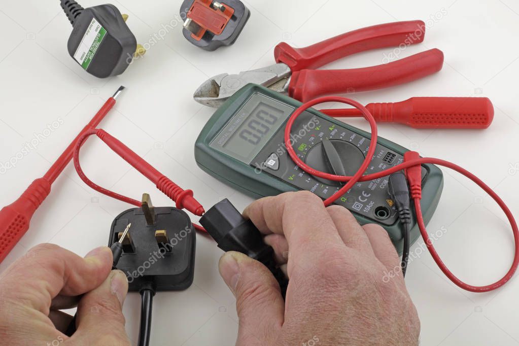 Earth continuity testing  An electrician testing a mains cable earth with a multimeter 