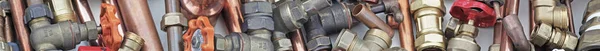 Plumber\'s pipes and fittings website banner    Wide  random mixture of copper pipe and brass fittings ideal for use as a website header  background