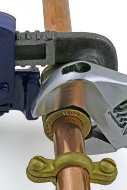 Bakır boru inşaat ayarlanabilir anahtarları, 15 mm bakır boru ve pirinç ek yerleri için hazır yeni birlikte gri bir arka plan karşı koydu