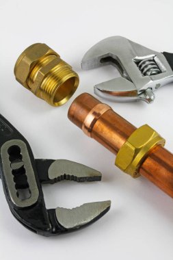 Bakır boru inşaat ayarlanabilir anahtarları, 15 mm bakır boru ve pirinç ek yerleri için hazır yeni birlikte gri bir arka plan karşı koydu