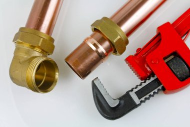 Tesisatçı boru A planı görünümü bir ayarlanabilir anahtarı ve gri bir arka plan üzerinde uygun bir sıkıştırma ile 15mm bakır boru