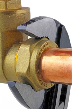 Tesisatçı 's ayarlanabilir anahtarı ayarlanabilir bir anahtar 15 mm bakır boru beyaz zemin üzerinde bir sıkıştırma kapısı Vana kadar sıkma kadar bakır boru sıkma