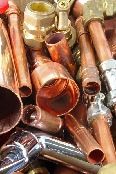 Plumber\'s pipes and fittings       Random mixture of copper pipe and brass fittings ideal for use as a website header  background