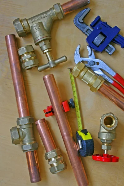 Plumber\'s pipes and fittings       Random mixture of copper pipe, tools and brass fittings ideal for use as a website header  background