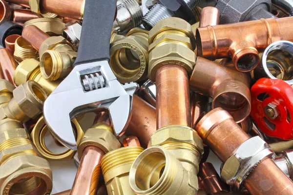 Plumber\'s pipes and fittings       Random mixture of copper pipe and brass fittings ideal for use as a website header  background