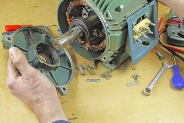 Üç fazlı endüksiyon motor taşıyan onarmak bir tesisatçı/motor sargıları direnç okuma bir multimetre ile kontrol ve şaft yatakları üzerinde hataları için kontrol teknisyeni, .