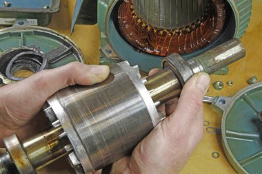 Üç fazlı endüksiyon motor taşıyan onarmak bir tesisatçı/motor sargıları direnç okuma bir multimetre ile kontrol ve şaft yatakları üzerinde hataları için kontrol teknisyeni