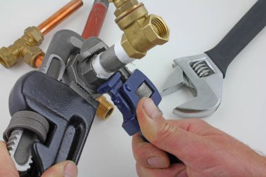 Demir boru kadar inşaat ayarlanabilir anahtarı için hazır hale, 15mm demir boru ve pirinç eklemler birlikte gri bir arka plan karşı koydu