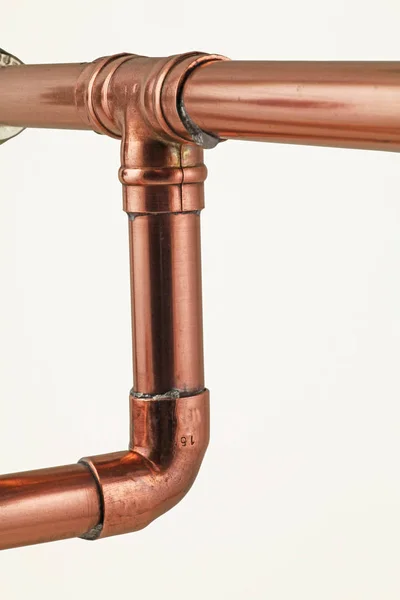 Pipework and fittings -  Copper pipe and solder fittings isolated on a white background
