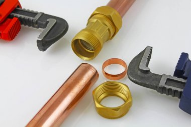 Bakır boru inşaat ayarlanabilir anahtarları, 15 mm bakır boru ve pirinç ek yerleri için hazır yeni birlikte gri bir arka plan karşı koydu