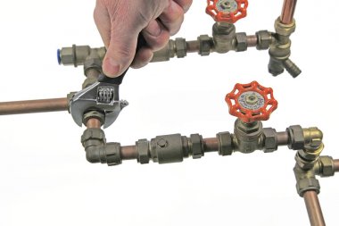 Boru işi kadar ayarlanabilir bir anahtarı tee-montaj üzerinde beyaz bir arka plan üzerinde izole 15 mm bakır boru sıkma sıkma tesisatçı