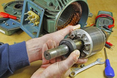 Üç fazlı endüksiyon motor taşıyan onarmak bir tesisatçı/teknisyen şaft yatakları değiştirme önce statör rotor kaldırılıyor