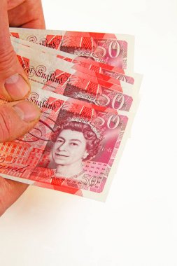 Para bir avuç beyaz bir arka plan üzerinde izole birkaç 50 Lirası notlar holding erkek eller sunan