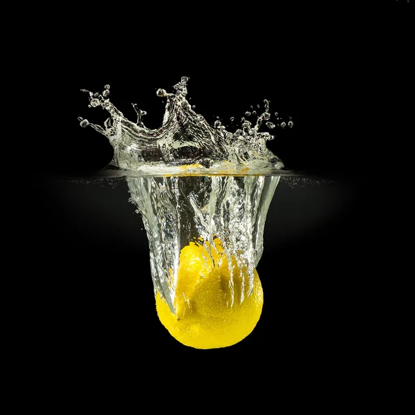 Frische Früchte fallen in Wasser mit Spritzer auf schwarzem Hintergrund — Stockfoto