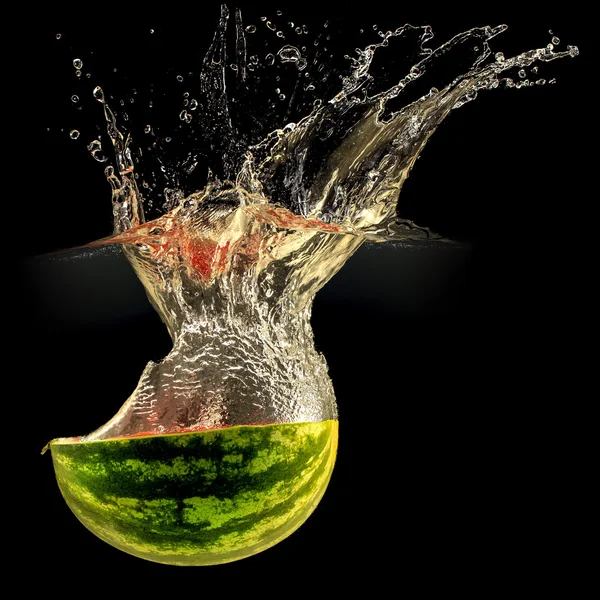 Frische Melone fällt in Wasser mit Spritzer auf schwarz — Stockfoto