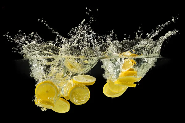Group of fresh fruits falling in water with splash on black back — Stock Photo, Image