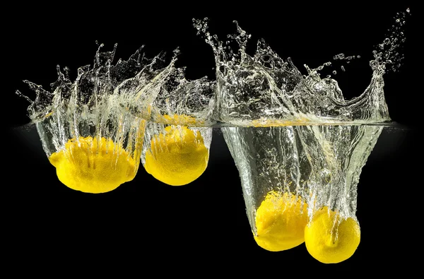 Grupo de frutas frescas que caem na água no preto — Fotografia de Stock