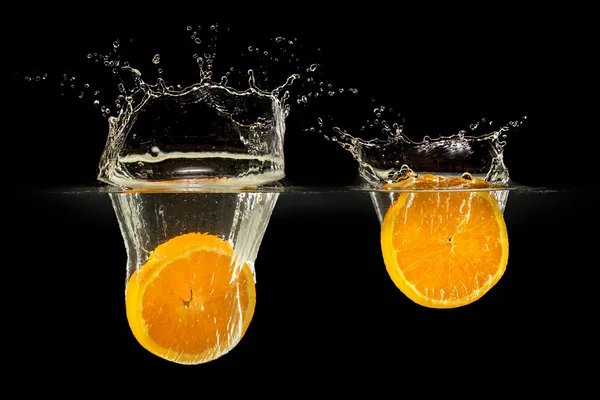 Group of fresh fruits falling in water with splash on black background — Stock Photo, Image