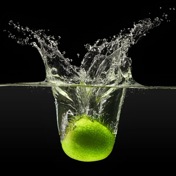 Green apple falling in water on black background — Stock Photo, Image