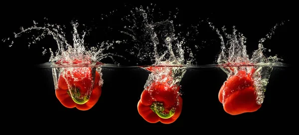 Red bell pepper falling in water — Stock Photo, Image