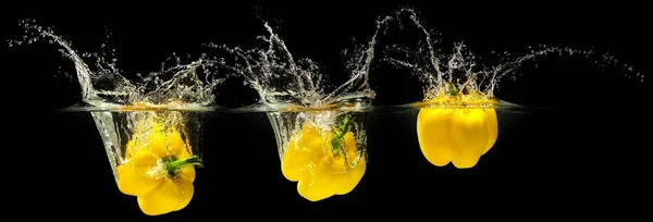 Yellow bell pepper falling in water — Stock Photo, Image
