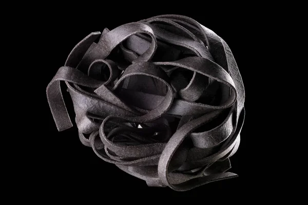 Макро фото гнезда Tagliatelle пасты или феттуцина изолированы на черном фоне — стоковое фото