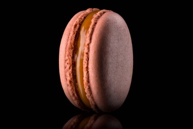 Fransız karamel badem kurabiyesinin siyah üzerinde yansıması olan makro fotoğrafı..