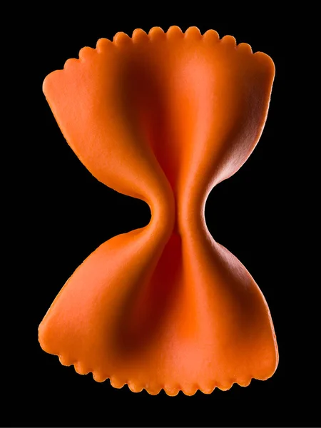 Makro-Foto von orangefarbenen Farfalle-Pasta isoliert auf schwarz mit Clipping-Pfad — Stockfoto