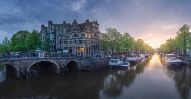 Suyun üzerindeki binaların yansımasıyla Amsterdam şehri manzarası