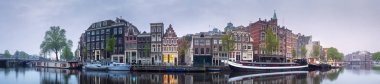 Suyun üzerindeki binaların yansımasıyla Amsterdam şehri manzarası