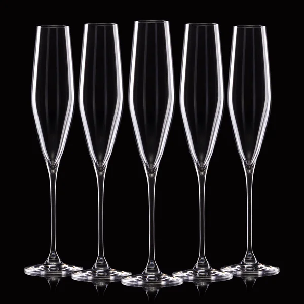 Sett med tomme, luksuriøse champagneglass på rad isolert på svart bakgrunn – stockfoto