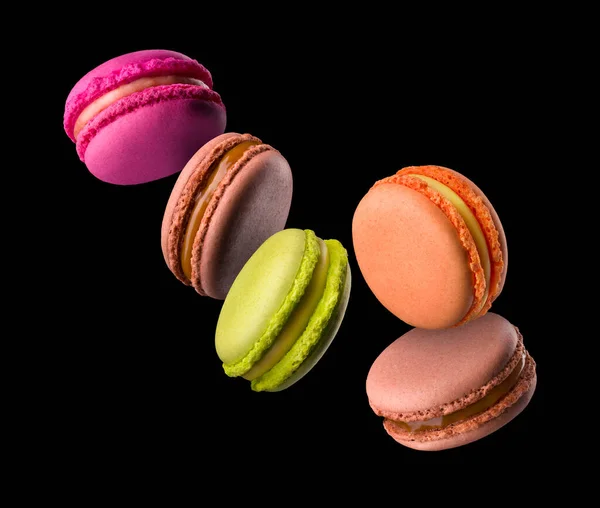 Flying french colorful macaroons on wooden table isolated on black — 스톡 사진