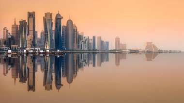 Batı Körfezi ve Doha Şehri 'nin silueti su üzerindeki binaların yansımasıyla, Katar
