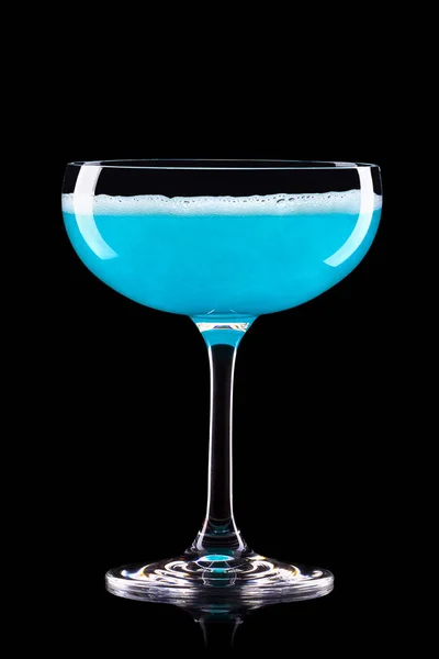 Glas für blauen Champagner mit Spritzern isoliert auf schwarzem Hintergrund. — Stockfoto