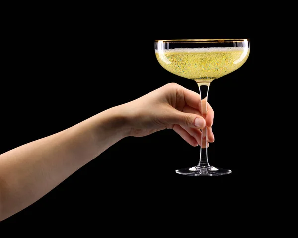 Woman hand holding glass of sparkling champagne isolated on black. — Stock fotografie